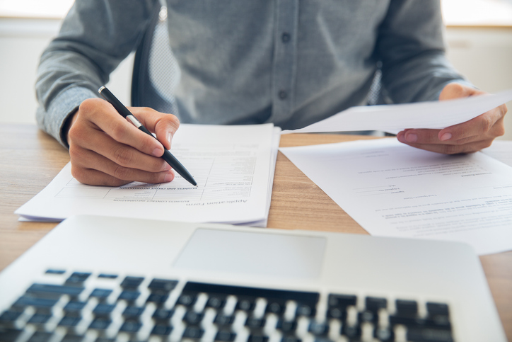 Adult reviewing official unclaimed property claim documents to recover funds held by a state program